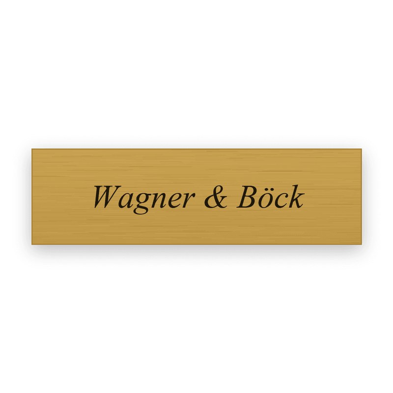 Rechteckiges goldfarbenes Einlegeschild mit schwarzer Gravur in kursiver Serifenschrift, eine Zeile mit Wagner & Böck