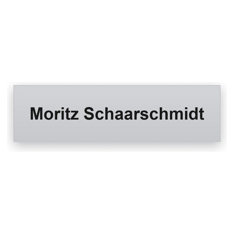 Rechteckiges silbern gebürstetes Namensschild mit schwarzer Gravur, eine Zeile mit Moritz Schaarschmidt
